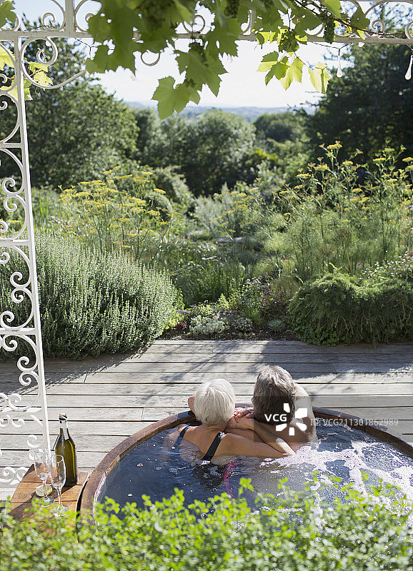 在阳光明媚的夏日露台上享受热水浴缸的情侣图片素材