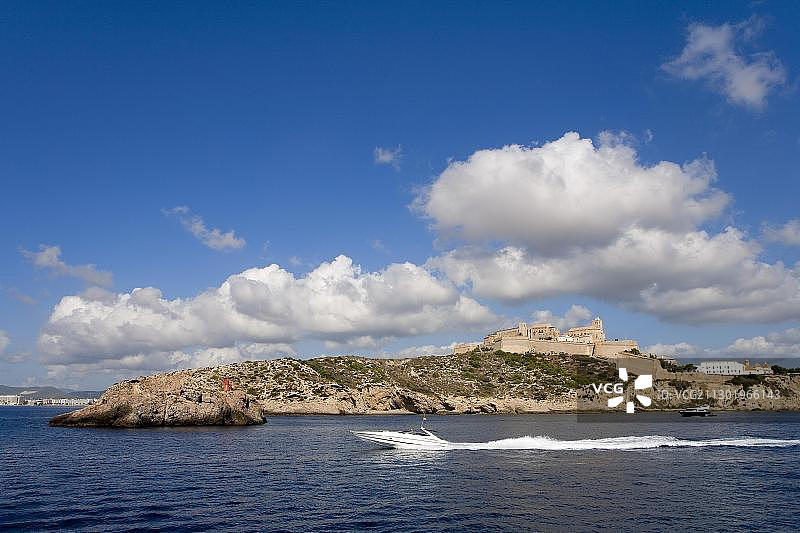 西班牙巴利阿里群岛伊维萨岛，透过海洋眺望海岸和达特维拉古城的景观图片素材