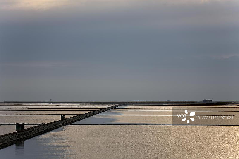 行驶在洛伦丹姆的两辆洛伦轨道车，途经北海到达德国石勒苏益格荷尔斯泰因州北弗里西亚瓦登海国家公园的霍利格诺德斯特兰迪斯奇莫尔图片素材