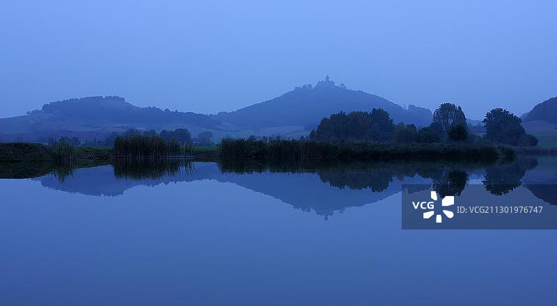 图林根州戈塔附近湖面倒影中的山丘和瓦克森堡城堡，德国图片素材