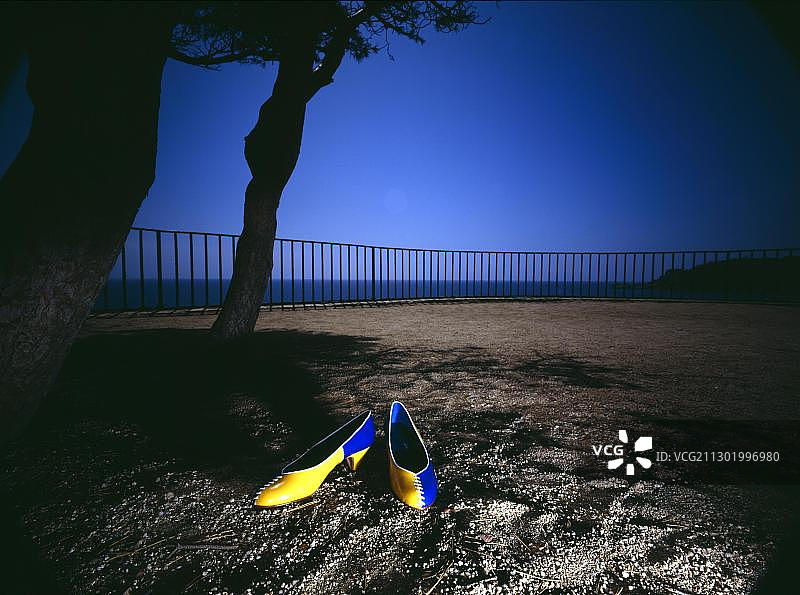 栏杆前的黄蓝色鞋子图片素材
