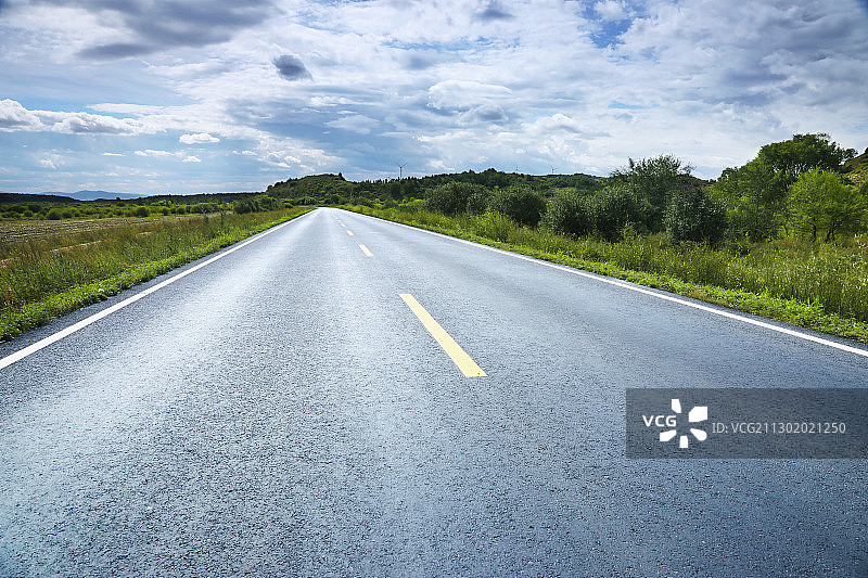 草原美景中一条柏油公路图片素材