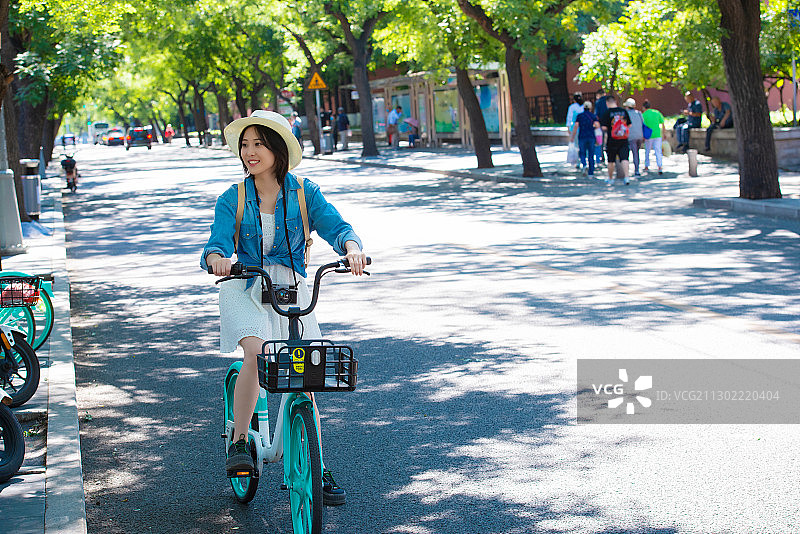 快乐女孩在骑共享单车旅行图片素材