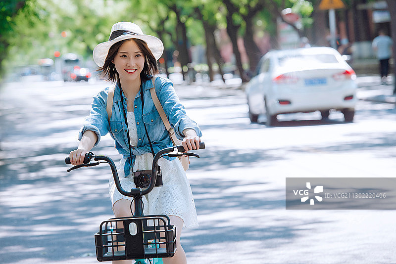 快乐女孩在骑共享单车旅行图片素材