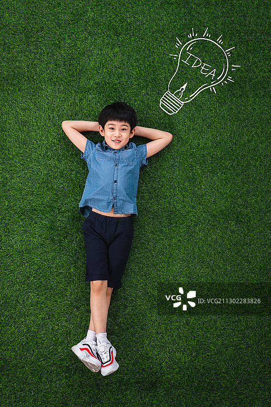 可爱的小男孩躺在草地上图片素材