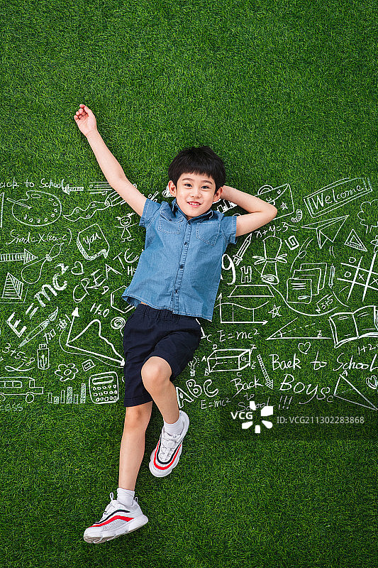 可爱的小男孩躺在草地上图片素材