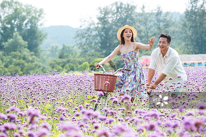 青年夫妇在花海里骑车图片素材