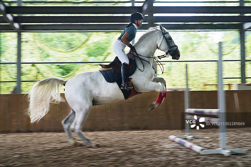 骑马跳障碍栏的帅气青少年女孩图片素材