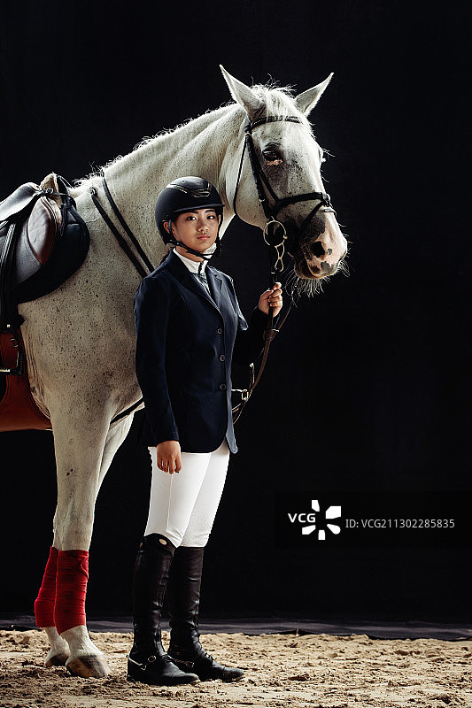 帅气的女孩牵着白马的肖像图片素材