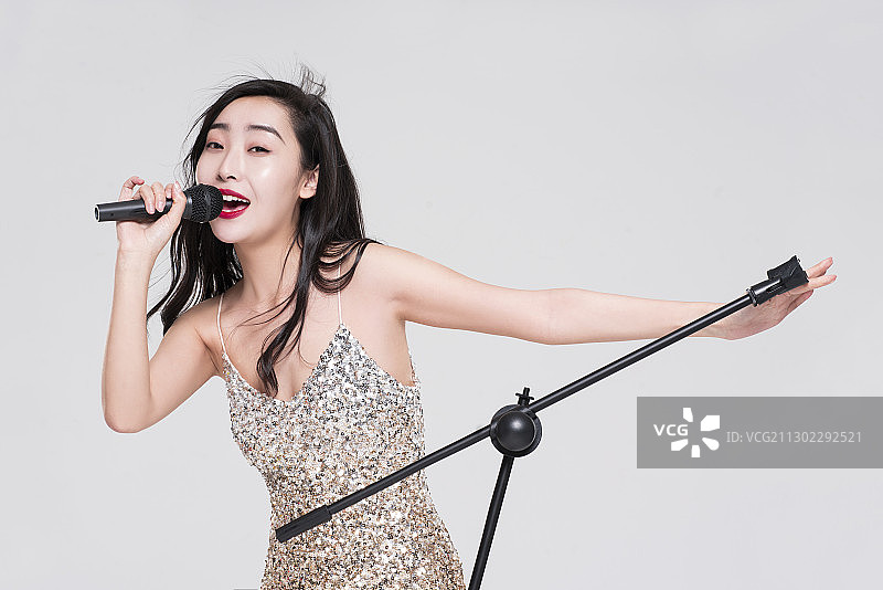 性感漂亮女子拿着麦克风唱歌图片素材