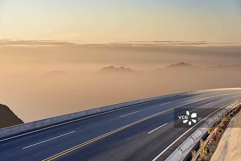 山峦前的一条双车道柏油路图片素材