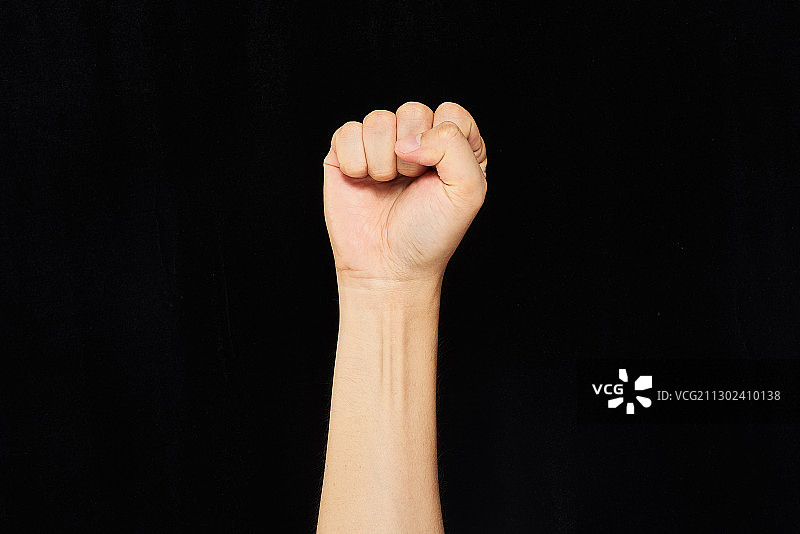 黑色背景上的人手握拳图片素材