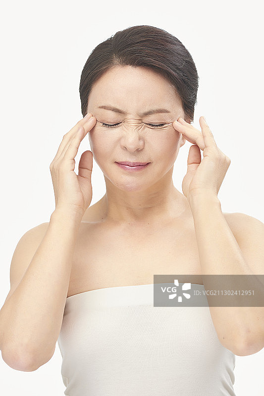 用手触摸眼角皱纹并皱眉的妇女图片素材