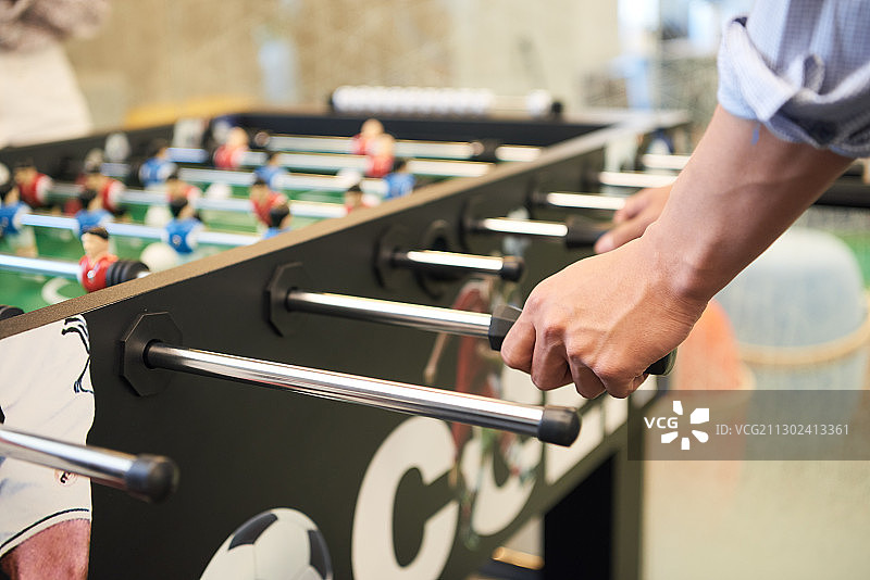 商人玩桌上足球的手部特写图片素材