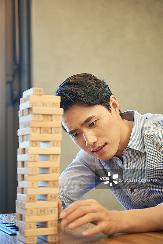 商务人士在办公室休息区玩层层叠图片素材