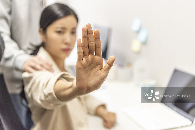 女商人做出手势拒绝办公室性骚扰图片素材