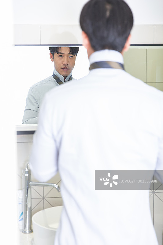 青年男子在卫生间戴领带图片素材