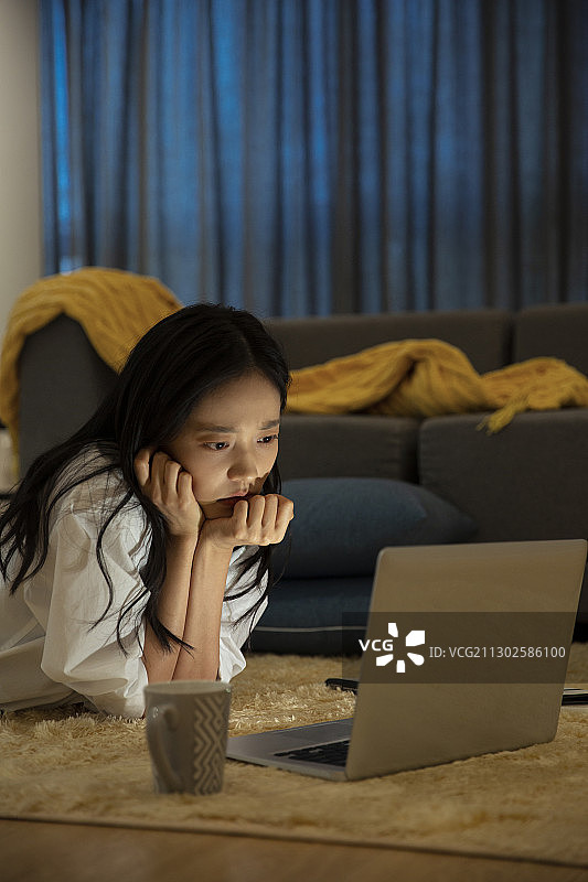 青年女子在客厅使用笔记本电脑工作图片素材