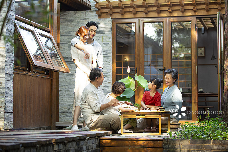 中秋节一家六口户外庭院下围棋嬉戏图片素材