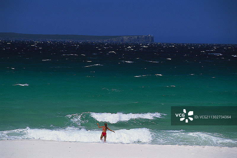 穿着比基尼的女人跑向海浪，澳大利亚新南威尔士州杰维斯湾海洋公园海姆斯海滩图片素材