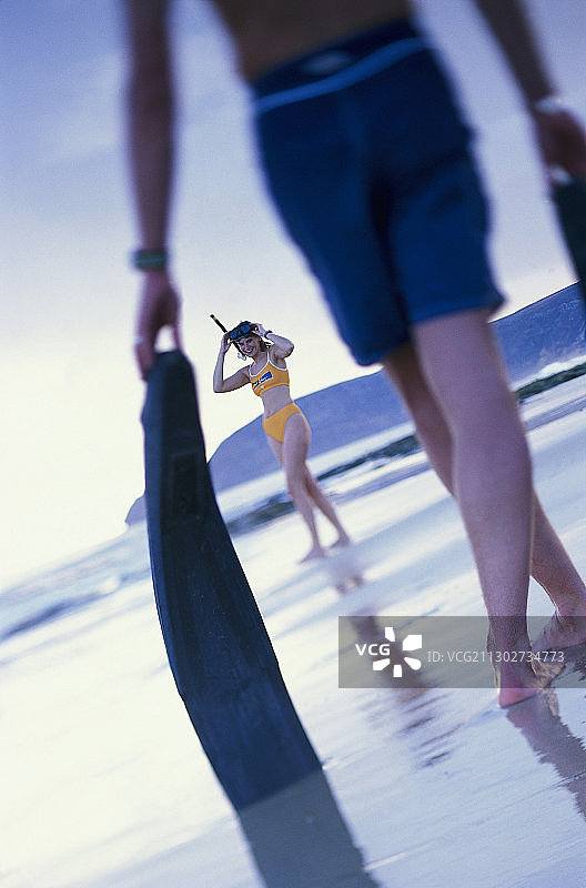 情侣在葡萄牙马德拉海滩上行走，带着脚蹼图片素材