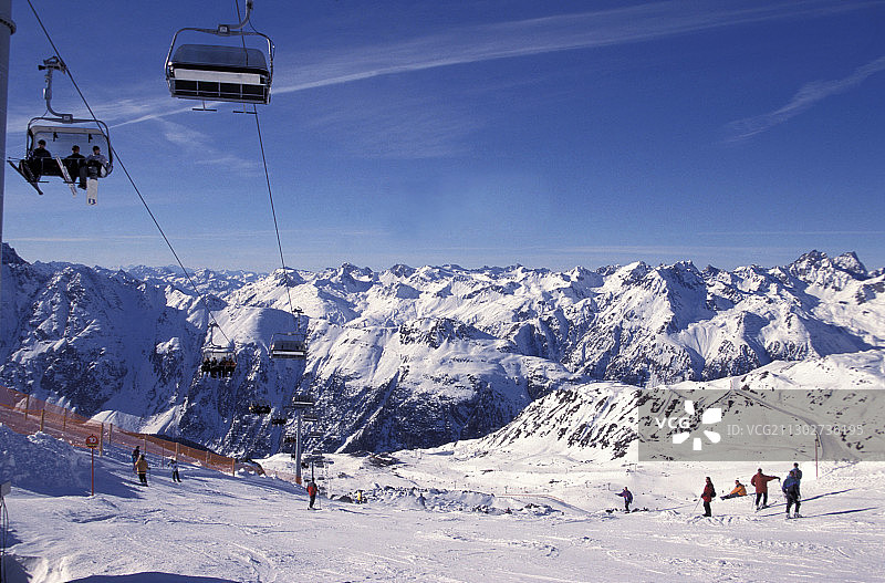 奥地利蒂罗尔州伊施格尔的滑雪坡上的缆车和滑雪者图片素材