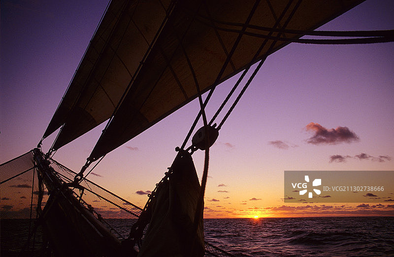 地平线上的浪漫日落，前景是船首斜桅和网，传统帆船，海洋，南太平洋图片素材