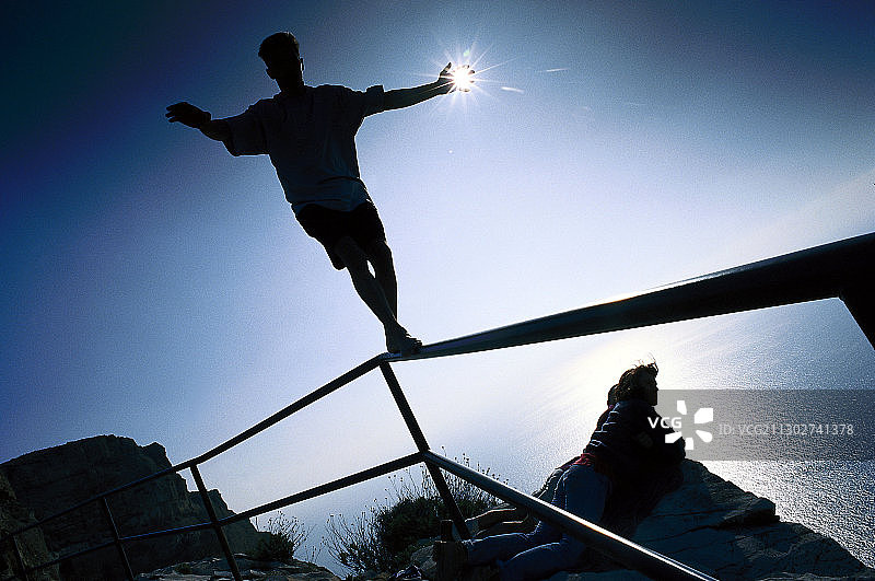 在法国卡朗克栏杆上保持平衡的青少年图片素材