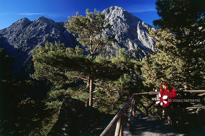 女人坐在克里特岛萨马利亚峡谷的长凳上图片素材