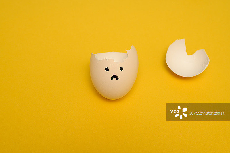 悲伤情绪-黄色背景上破碎的蛋壳图片素材