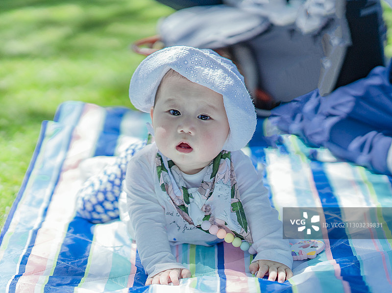 野餐垫上的快乐女婴宝宝图片素材