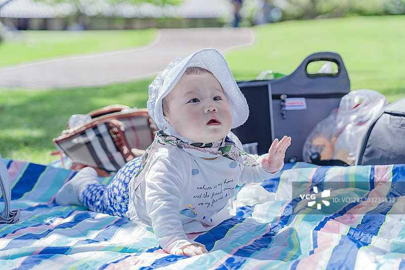 野餐垫上的快乐女婴宝宝图片素材