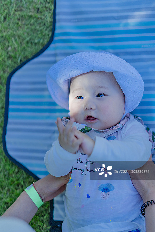 躺在野餐垫上的女婴宝宝图片素材