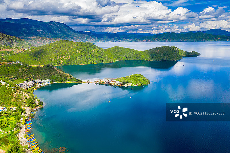 航拍泸沽湖里格半岛，蓝天白云倒映在平静的湖面图片素材