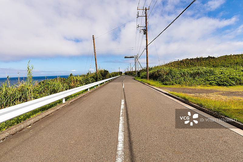 东京大岛：天空下的树木与空旷道路图片素材