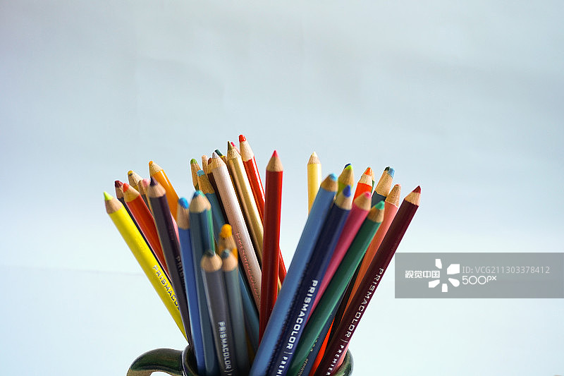 桌子上桌面收纳盒中的彩色铅笔特写图片素材