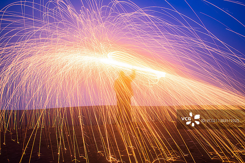 男人在夜晚旋转钢丝棉图片素材