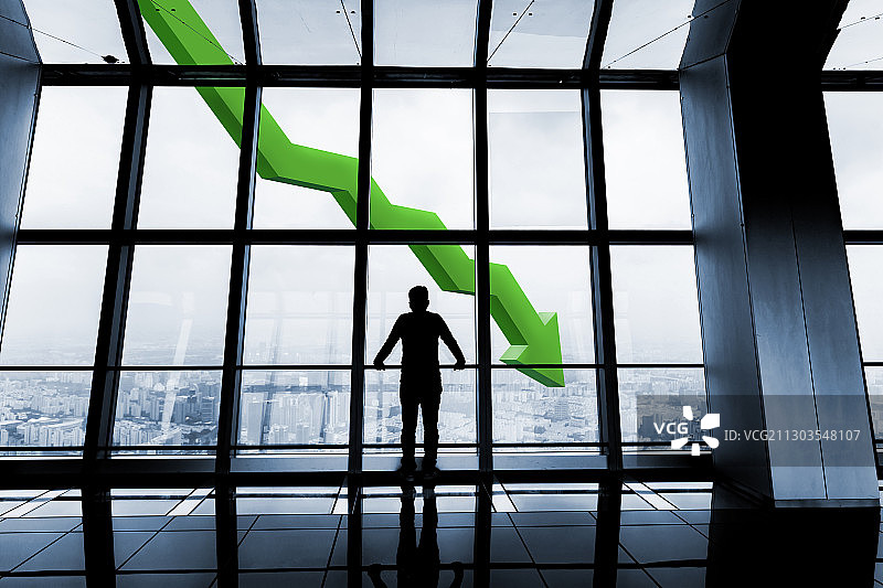 面对下跌箭头的商务男士剪影图片素材