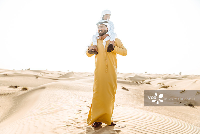 在海滩上抱着男婴的男人全身照图片素材