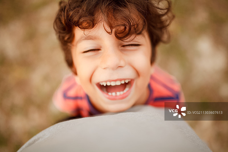 快乐的男孩在公园里玩球图片素材