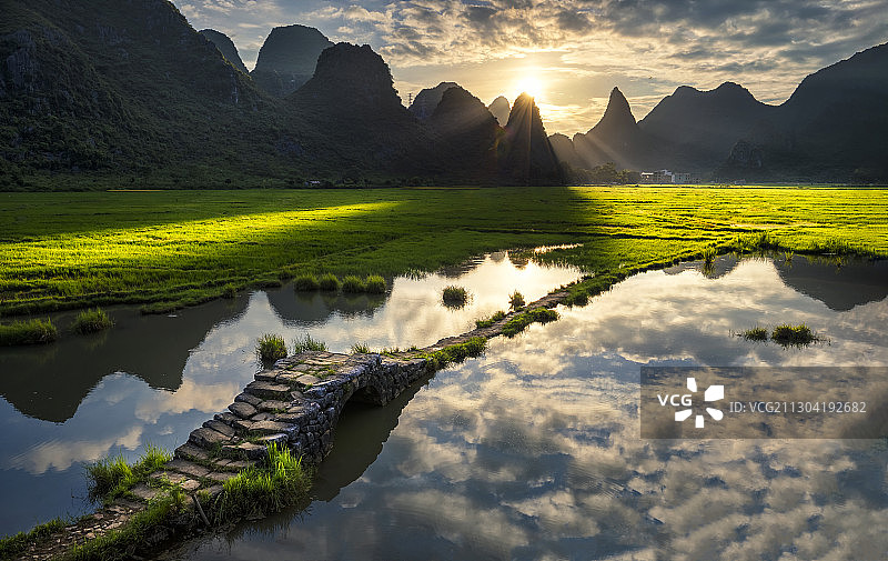 广西壮族自治区桂林市田心村状元桥的清晨，太阳从群山间升起图片素材