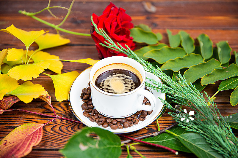 一杯放在木头桌子上的卡布奇诺拿铁美式咖啡与咖啡勺玫瑰图片素材