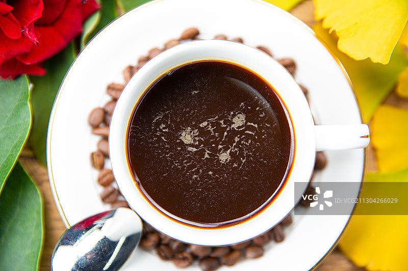 一杯放在木头桌子上的卡布奇诺拿铁美式咖啡与咖啡勺玫瑰图片素材