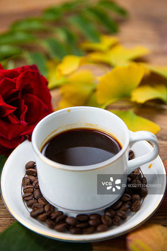 一杯放在木头桌子上的卡布奇诺拿铁美式咖啡与咖啡勺玫瑰图片素材