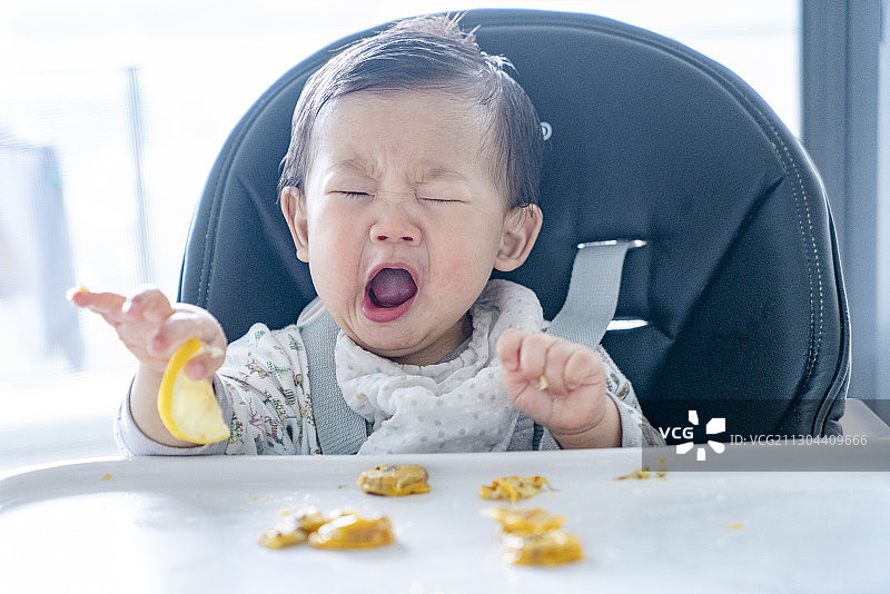 婴儿馋吃柠檬时的酸表情图片素材