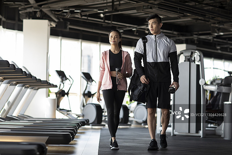 年轻情侣在健身房健身图片素材