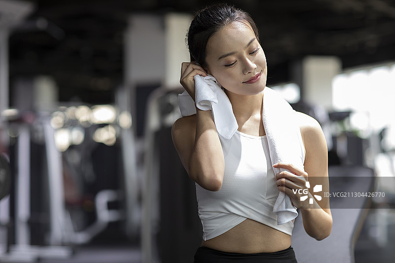 年轻女士在健身房健身后休息图片素材