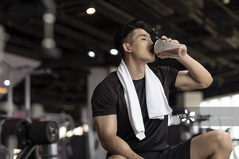 年轻男士在健身房健身后休息图片素材