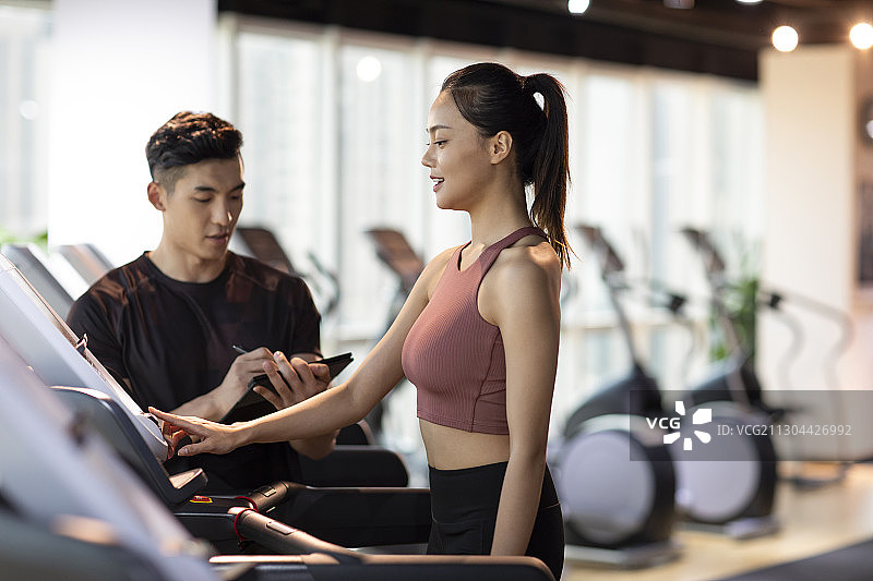 年轻女士在健身房上私教课图片素材