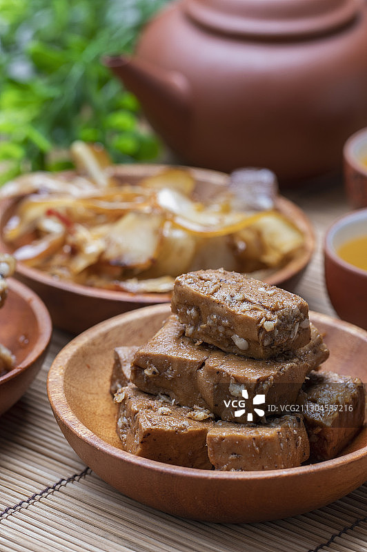 竹簾上有三盤美味的滷味和一壺清新的茶图片素材